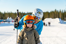 Pappa och son åker åkband i barnbacken - lärorik skidåkning för barn i Orsa Grönklitt.