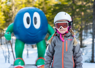 Flicka i alpinutrustning med Bärra Blåbär i bakgrunden