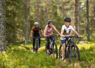 Familj som cyklar mountainbike på våra cykelleder i Orsa Grönklitt