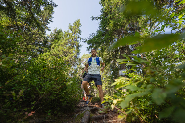 En kille i full färd med traillöpning i Orsa Grönklitts natursköna skogar - en energifylld löparupplevelse i naturen.
