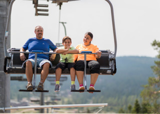 Familj åker sittlift upp för berget i Orsa Grönklitt - spännande upplevelse.