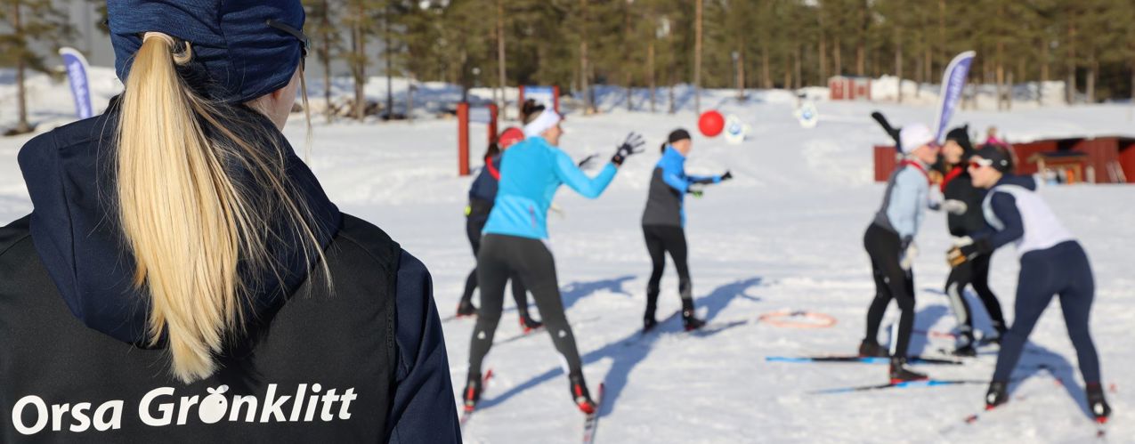 Skidlärare i Orsa Grönklitt som håller lektion med skidelever som tränar kordination med en boll. 