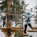 Familj som klättrar över hinder i luften i Grönklitts klätterpark