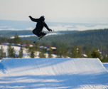 Pojke som hoppar med slalomskidor i snowparken i Orsa Grönklitt