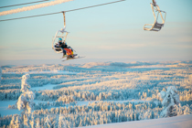 Familj åker sittlift i vintermiljö - alpin skidglädje i Orsa Grönklitt.