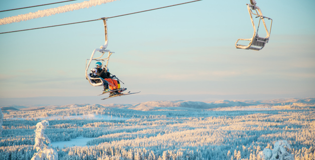 Familj åker sittlift i vintermiljö - alpin skidglädje i Orsa Grönklitt.