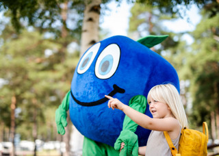 Flicka med Blåbäret Bärra på äventyr i Orsa Grönklitt - redo för spännande upplevelser med gulväska på ryggen.