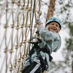 Flickebarn klättrar i nätet i Klätterparken, Orsa Grönklitt