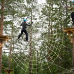 Unga killar klättrar i spindelnätet i Klätterparken, Orsa Grönklitt