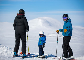 Familj som åker skidor på fjället
