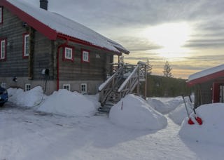 Stuga i vinterlandskap, belägen i Blåbärsbyn i Orsa Grönklitt. 