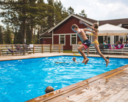 Barn som hoppar från poolkanten i Orsa Grönklitt
