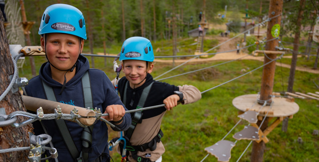 Två pojkar som klättrar i Grönkitts klätterpark