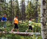 Familjen i harmoni - mamma, pappa och barn vandrar tillsammans i Orsa Grönklitts vackra skogar och njuter av naturen tillsammans.